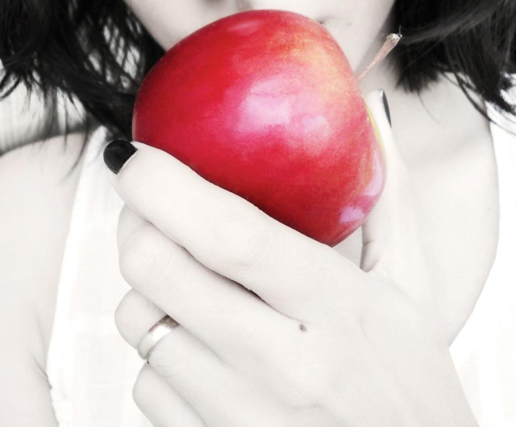 Eve or Snow White about to eat the apple of temptation
